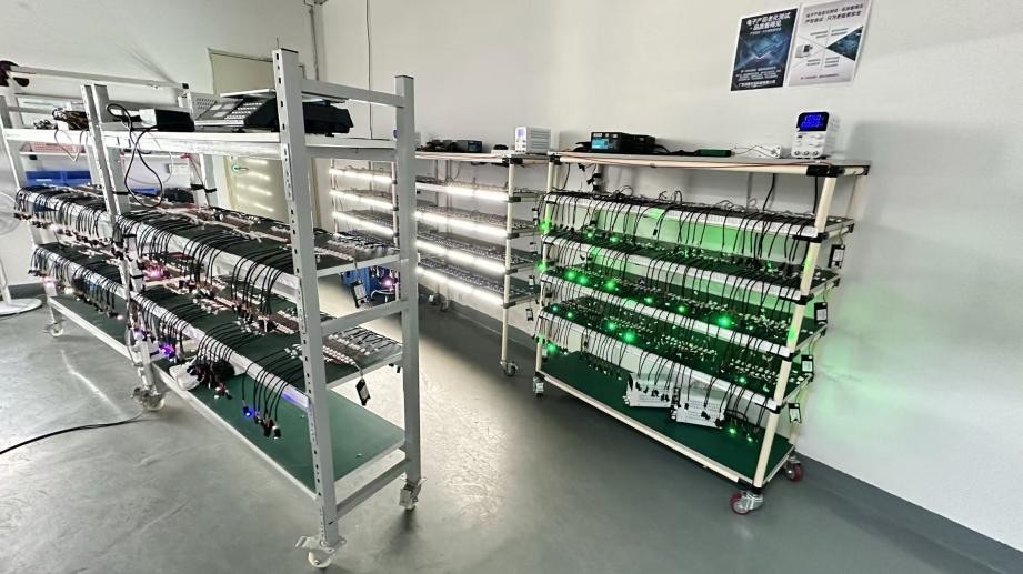 Rows of illuminated components connected on racks in the CKCP workshop